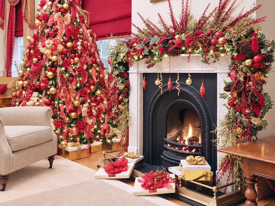 Fireplace in a Ledbury home dressed with a red and gold garland beside a matching Christmas tree