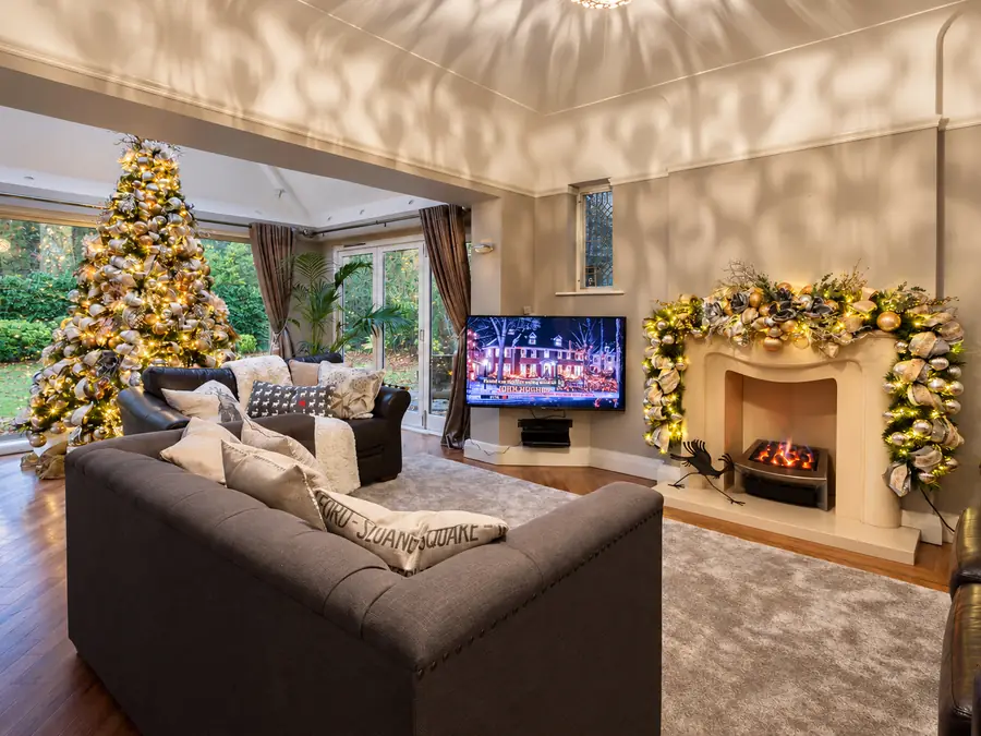 Living room with a gold and silver Christmas tree and a matching garland around the fireplace